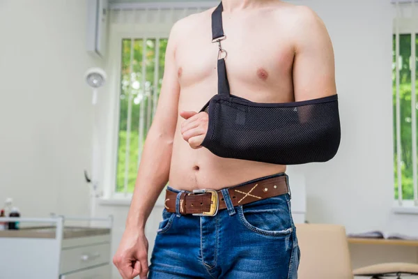 Man with a arm sling. Broken arm, shoulder. Injury