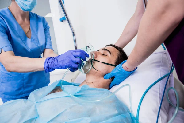 Doctors give resuscitation to a male patient in the emergency room. Cardiac massage