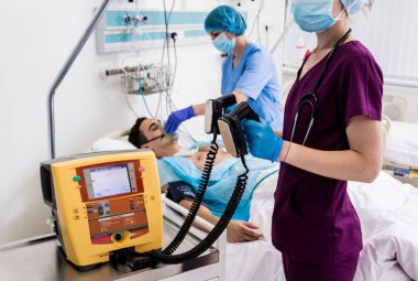 Doktorlar acil serviste erkek bir hastaya canlandırma emri verdi. Kalp masajı.