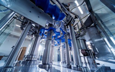 Otomatik doldurma makinesi plastik şişelere su dolduruyor, endüstriyel arka plan