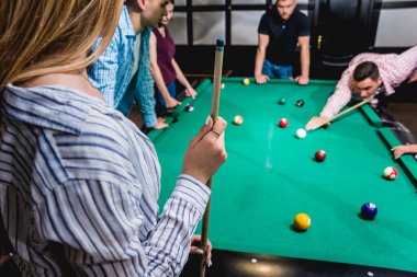 Bilardo oynayan bir grup neşeli genç arkadaş. İşten sonra eğlenceli zamanlar.