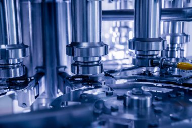 Otomatik doldurma makinesi plastik şişelere su dolduruyor, endüstriyel arka plan