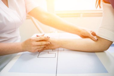 Radyolog ve hasta röntgen odasında. İnsan elinin röntgeni. Klasik tavana monte edilmiş x-ray sistemi