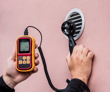 Technician use hand-held anemometer measuring air flowing measurement clipart