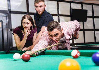 Bilardo oynayan bir grup neşeli genç arkadaş. İşten sonra eğlenceli zamanlar.