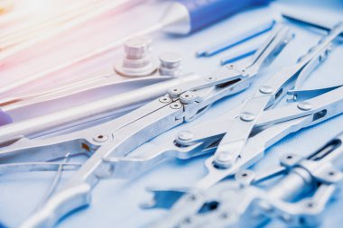 Sterilize edilmiş cerrahi aletler ve aletler mavi masada.