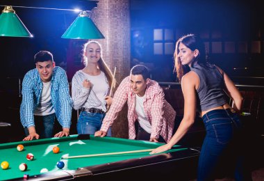 Bilardo oynayan bir grup neşeli genç arkadaş. İşten sonra eğlenceli zamanlar.