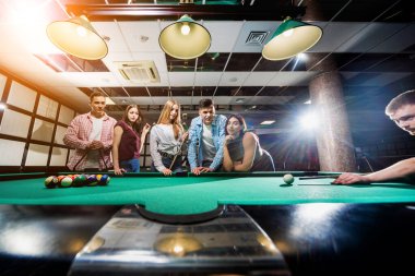 Bilardo oynayan bir grup neşeli genç arkadaş. İşten sonra eğlenceli zamanlar.