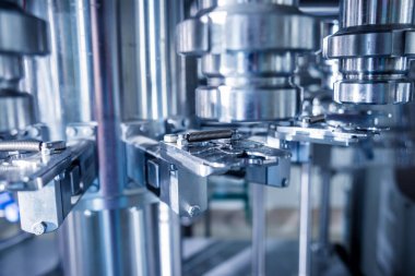 Otomatik doldurma makinesi plastik şişelere su dolduruyor, endüstriyel arka plan