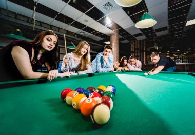 Bilardo oynayan bir grup neşeli genç arkadaş. İşten sonra eğlenceli zamanlar.
