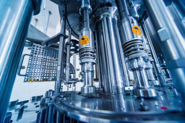 Otomatik doldurma makinesi plastik şişelere su dolduruyor, endüstriyel arka plan