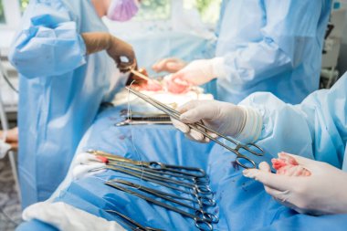 Cerrah ve asistanlar ameliyathanede ameliyat ekipmanlarıyla. Tıbbi geçmiş