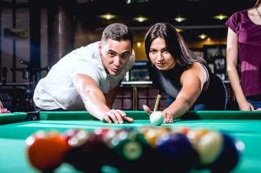 Bilardo oynayan bir grup neşeli genç arkadaş. İşten sonra eğlenceli zamanlar.