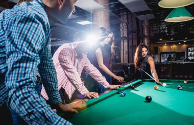 Bilardo oynayan bir grup neşeli genç arkadaş. İşten sonra eğlenceli zamanlar.