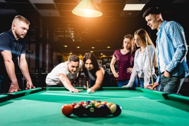 Bilardo oynayan bir grup neşeli genç arkadaş. İşten sonra eğlenceli zamanlar.