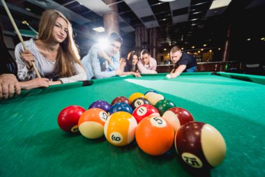 Bilardo oynayan bir grup neşeli genç arkadaş. İşten sonra eğlenceli zamanlar.