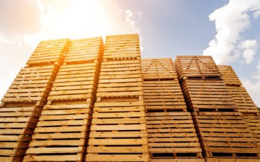 Mavi gökyüzü arka planında ahşap kutular üst üste dizilmiş