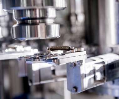 Otomatik doldurma makinesi plastik şişelere su dolduruyor, endüstriyel arka plan