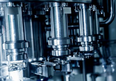 Otomatik doldurma makinesi plastik şişelere su dolduruyor, endüstriyel arka plan