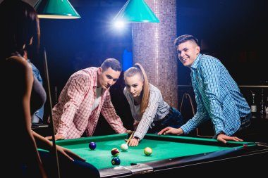 Bilardo oynayan bir grup neşeli genç arkadaş. İşten sonra eğlenceli zamanlar.