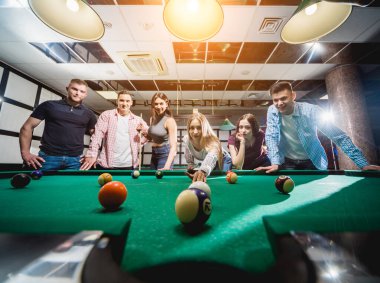 Bilardo oynayan bir grup neşeli genç arkadaş. İşten sonra eğlenceli zamanlar.