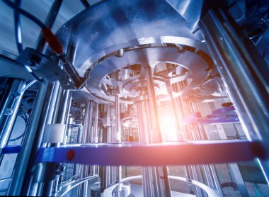 Otomatik doldurma makinesi plastik şişelere su dolduruyor, endüstriyel arka plan