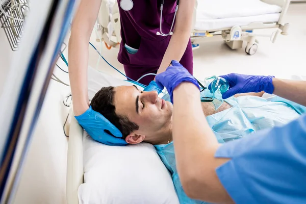 I medici danno rianimazione a un paziente di sesso maschile al pronto soccorso. Massaggio cardiaco — Foto Stock