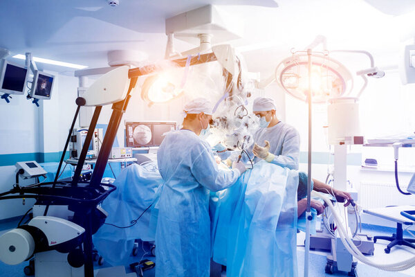 Операция на позвоночнике. Группа хирургов в операционной с хирургическим оборудованием. Ламинэктомия. Современное медицинское образование
