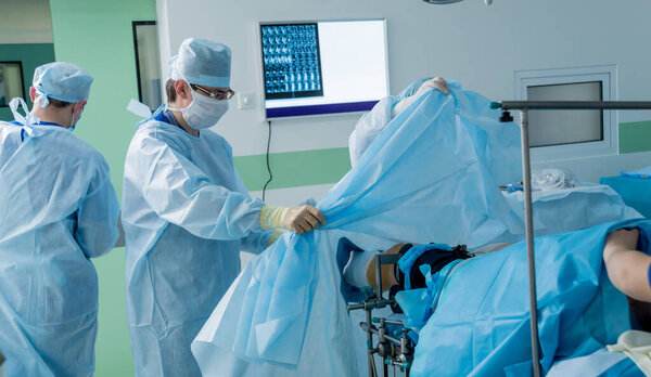 Arthroscope surgery. Orthopedic surgeons in teamwork in the operating room with modern arthroscopic tools. Knee surgery. Hospital background