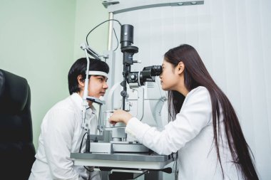 Bir göz doktoruna danışıyorum. Genç Asyalı erkek ve kadın doktor 