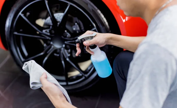 Trabajador de servicio de coche puliendo ruedas de coche con tela de microfibra. —  Fotos de Stock