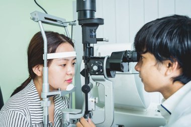 Bir göz doktoruna danışıyorum. Genç Asyalı kadın ve doktor