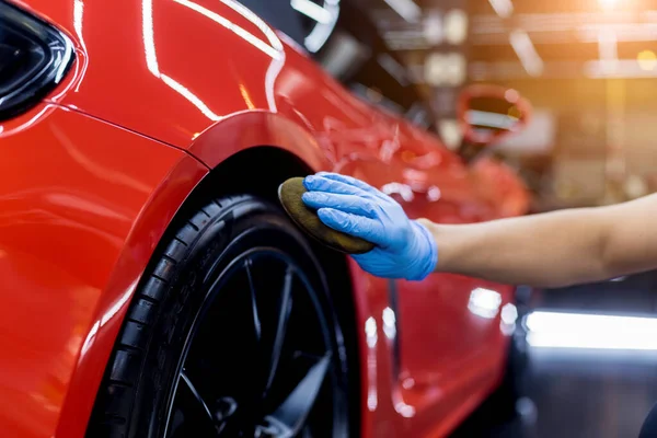 Autoservice-Mitarbeiter poliert Autoräder mit Mikrofasertuch. — Stockfoto