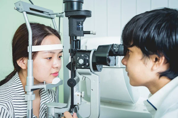 Consulta con un oftalmólogo. Joven mujer asiática y médico —  Fotos de Stock
