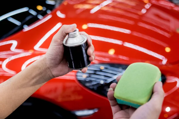 Trabajador de servicio de coches aplicando nano recubrimiento en un detalle del coche —  Fotos de Stock