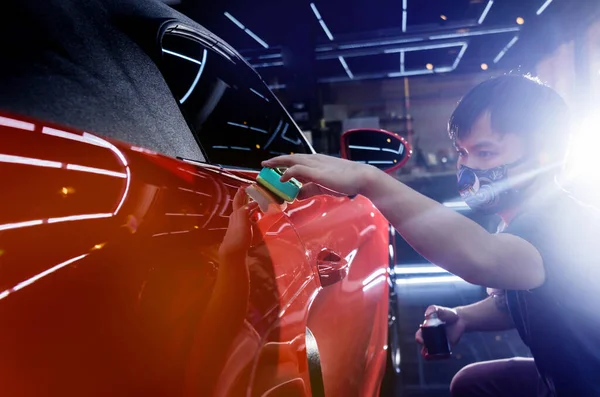 Trabajador de servicio de coches aplicando nano recubrimiento en un detalle del coche — Foto de Stock