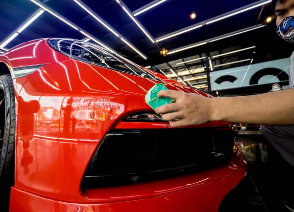 Trabalhador de serviço de carro aplicando revestimento nano em um detalhe do carro — Fotografia de Stock