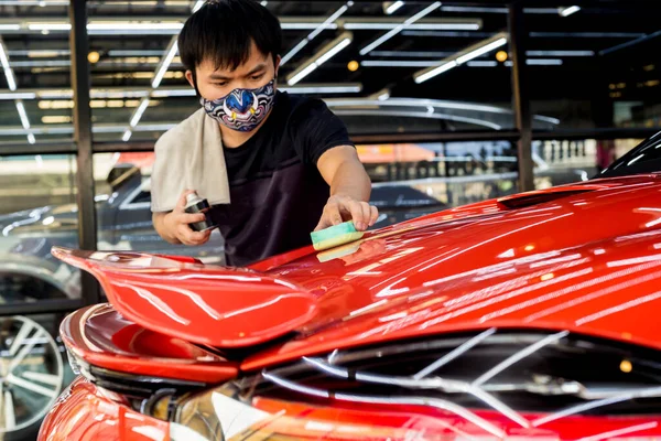 Trabalhador de serviço de carro aplicando revestimento nano em um detalhe do carro — Fotografia de Stock