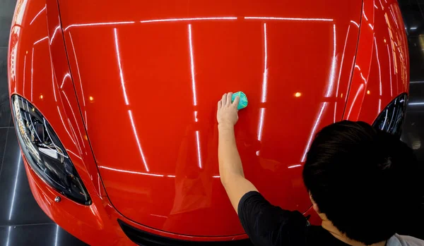 Trabajador de servicio de coches aplicando nano recubrimiento en un detalle del coche —  Fotos de Stock