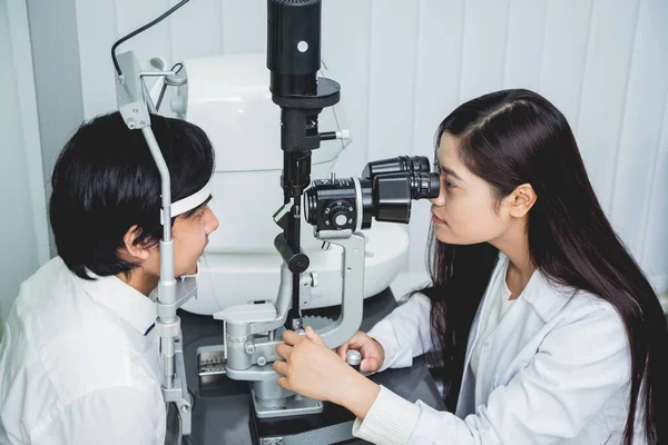 Bir göz doktoruna danışıyorum. Genç Asyalı erkek ve kadın doktor 