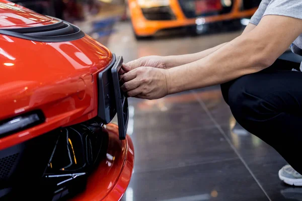 Técnico cambiando el número de placa del coche en el centro de servicio . —  Fotos de Stock