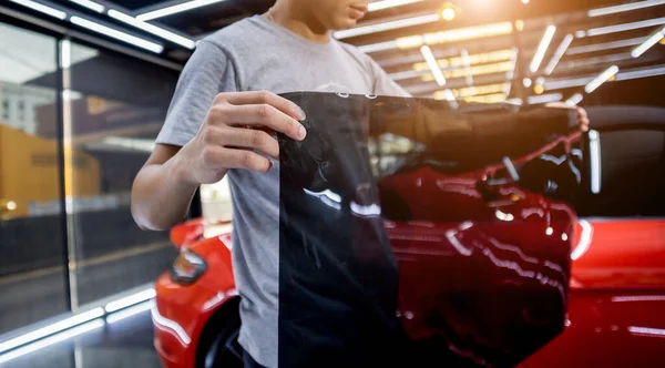 Aplicando folha de tintura em uma janela de carro em um serviço de auto — Fotografia de Stock