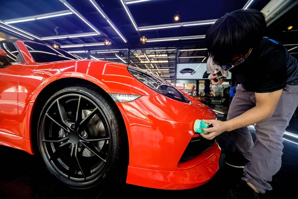 Trabalhador de serviço de carro aplicando revestimento nano em um detalhe do carro — Fotografia de Stock