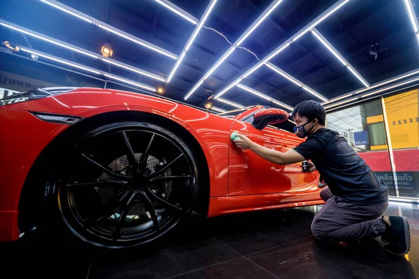 Trabajador de servicio de coches aplicando nano recubrimiento en un detalle del coche —  Fotos de Stock