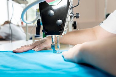 Elbiseyi tasarımcı terzi diker. Kadın işi için dikiş makinesi kullanıyor..