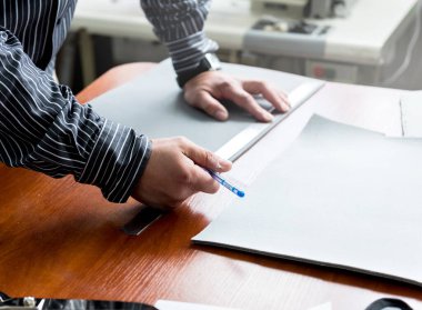 Tasarımcı koltuk kılıflarını diker. Adam işi için dikiş makinesi kullanıyor..