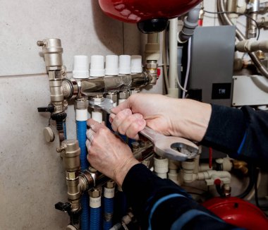 Isıtma mühendisi kazan dairesine modern ısıtma sistemi kuruyor.