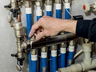 Isıtma mühendisi kazan dairesinde modern ısıtma sistemini tamir ediyor.. 