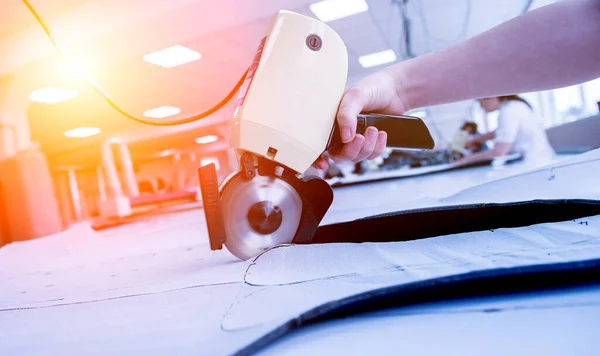 Vrouwelijke werknemer maakt gebruik van elektrische snijden stof machine. Productie van stoffen — Stockfoto