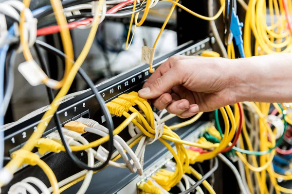 Engenheiro de rede a trabalhar na sala de servidores. Conectando cabos de rede aos switches — Fotografia de Stock